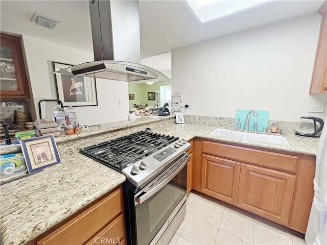 13722 Red Hill Ave Unit 15, Tustin, CA 92780 - kitchen featuring stainless steel gas stove, island range hood, light stone countertops, and light tile patterned floors