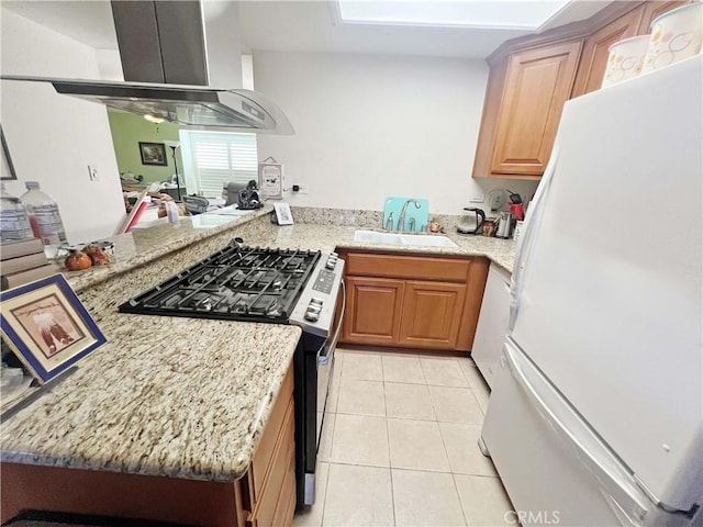 13722 Red Hill Ave Unit 15, Tustin, CA 92780 - kitchen featuring stainless steel gas range oven, freestanding refrigerator, range hood, light tile patterned flooring, and light stone countertops