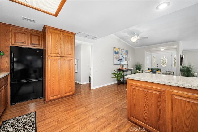 13311 Twin Hills Rd Unit 55H, Seal Beach, CA 90740 - kitchen featuring freestanding refrigerator, crown molding, light wood finished floors, light countertops, and brown cabinetry