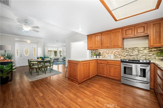 13311 Twin Hills Rd Unit 55H, Seal Beach, CA 90740 - kitchen with stainless steel range with electric stovetop, a peninsula, brown cabinets, and ornamental molding
