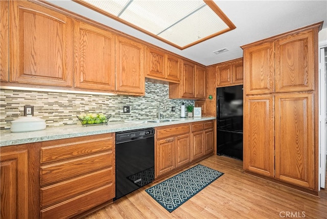 13311 Twin Hills Rd Unit 55H, Seal Beach, CA 90740 - kitchen with black appliances, light wood-type flooring, tasteful backsplash, and brown cabinetry