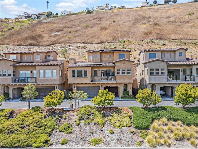 1009 Price Canyon Rd, Pismo Beach, CA 93449 - rear view of house with an attached garage, stucco siding, a balcony, and driveway