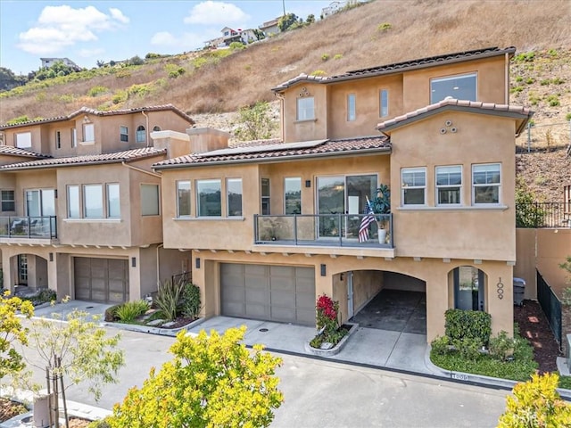 1009 Price Canyon Rd, Pismo Beach, CA 93449 - view of front of home with a balcony, stucco siding, and roof mounted solar panels