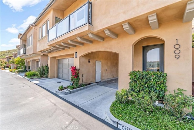1009 Price Canyon Rd, Pismo Beach, CA 93449 - doorway to property with an attached garage, stucco siding, and concrete driveway