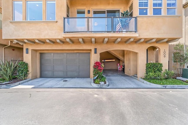 1009 Price Canyon Rd, Pismo Beach, CA 93449 - view of front facade featuring a balcony, an attached garage, concrete driveway, and stucco siding
