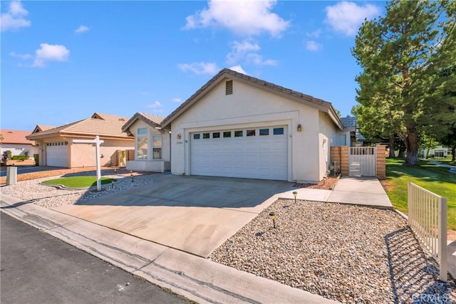 11246 Pleasant Hills Dr, Apple Valley, CA 92308 - ranch-style house featuring stucco siding, an attached garage, driveway, a tile roof, and a gate