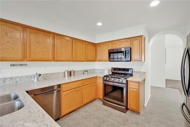 11246 Pleasant Hills Dr, Apple Valley, CA 92308 - kitchen featuring appliances with stainless steel finishes, light stone counters, recessed lighting, arched walkways, and light tile patterned flooring