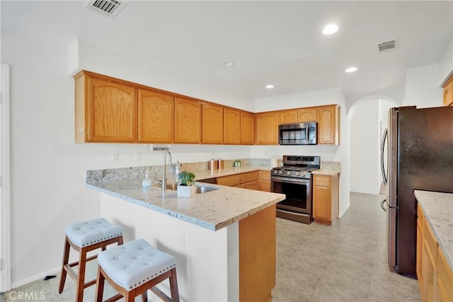 11246 Pleasant Hills Dr, Apple Valley, CA 92308 - kitchen with appliances with stainless steel finishes, a peninsula, a breakfast bar, arched walkways, and recessed lighting