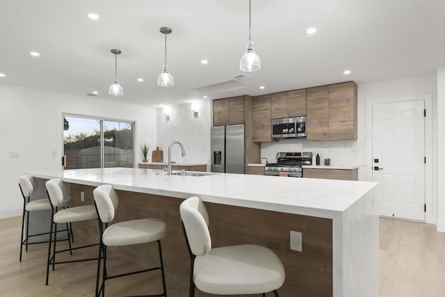 4143 Cole Way, San Diego, CA 92117 - kitchen with stainless steel appliances, light wood-style flooring, recessed lighting, light countertops, and decorative backsplash
