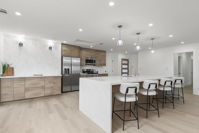 4143 Cole Way, San Diego, CA 92117 - kitchen with stainless steel appliances, light wood-style flooring, recessed lighting, a large island with sink, and modern cabinets