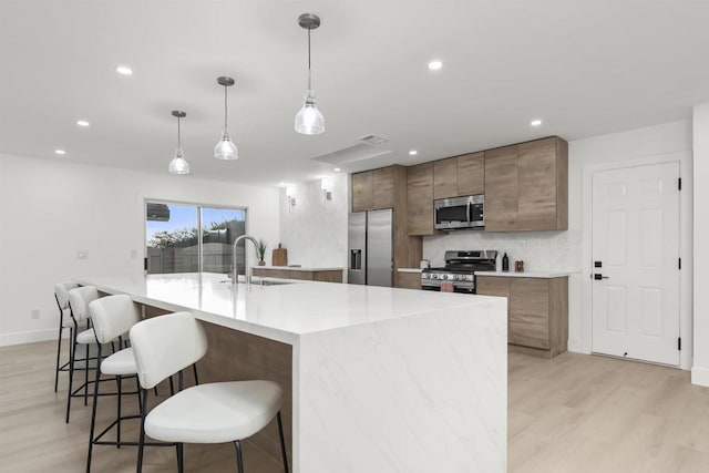 4143 Cole Way, San Diego, CA 92117 - kitchen featuring stainless steel appliances, light wood finished floors, a kitchen bar, modern cabinets, and recessed lighting