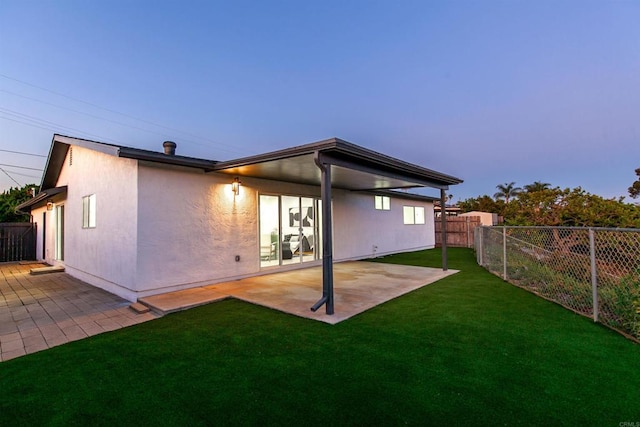 4143 Cole Way, San Diego, CA 92117 - back of property at dusk with a fenced backyard, stucco siding, and a patio