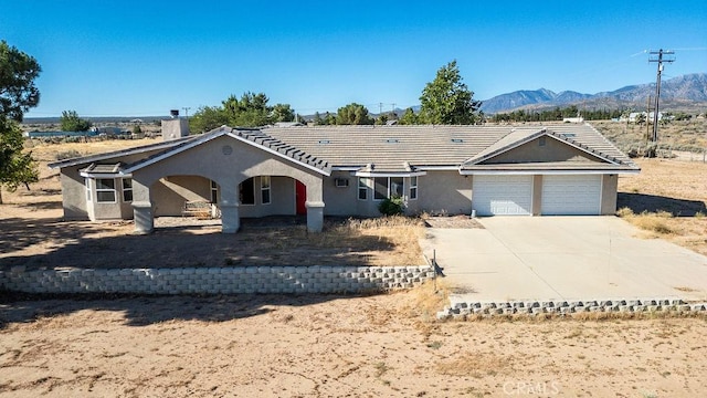 8851 Sonora Rd, Phelan, CA 92371 - single story home with an attached garage, stucco siding, a mountain view, driveway, and a tile roof