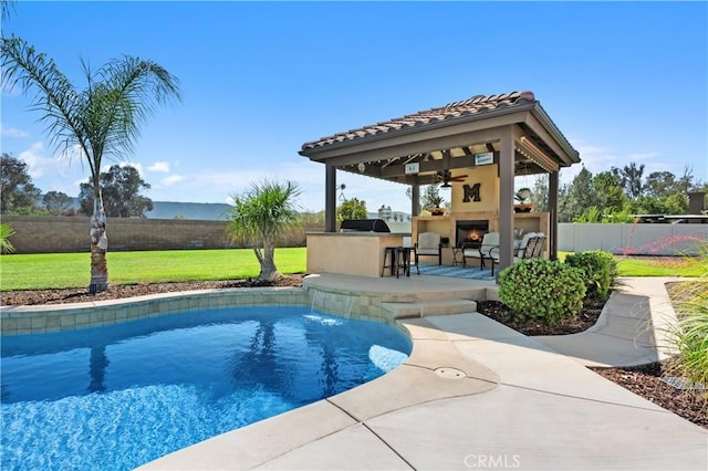 41798 Aviv Ct, Murrieta, CA 92562 - view of pool with a fenced backyard, a patio area, exterior kitchen, a ceiling fan, and a lit fireplace
