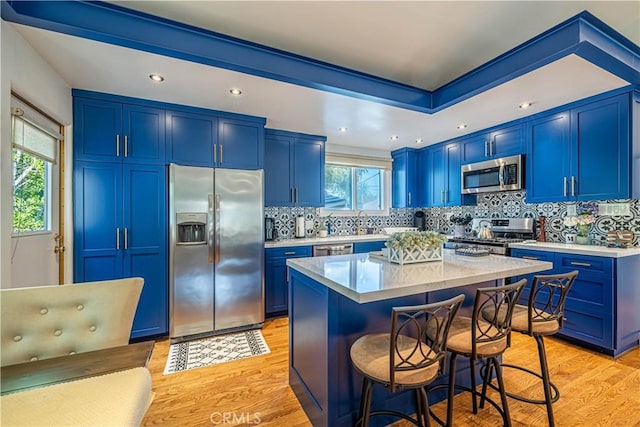 8638 Yorktown Ave, Los Angeles, CA 90045 - kitchen with appliances with stainless steel finishes, blue cabinets, a kitchen bar, light wood-type flooring, and recessed lighting