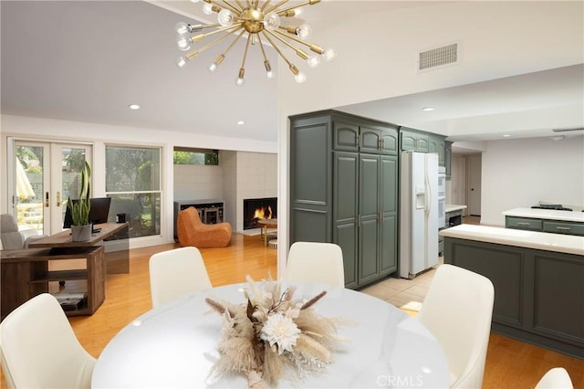 2911 Walker Lee Dr, Rossmoor, CA 90720 - dining room featuring a chandelier, light wood-style flooring, french doors, recessed lighting, and a large fireplace