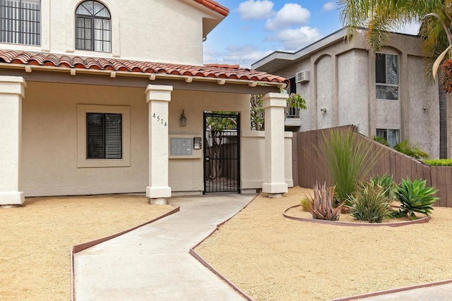 4514 Dawson Ave Unit 2, San Diego, CA 92115 - property entrance featuring a tiled roof, a gate, stucco siding, and a wall mounted AC