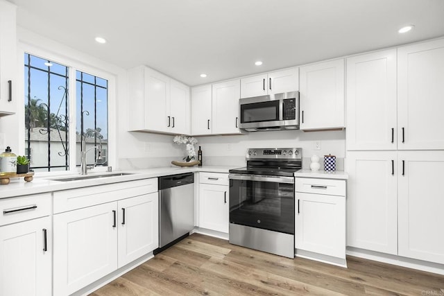 4514 Dawson Ave Unit 4, San Diego, CA 92115 - kitchen with appliances with stainless steel finishes, light countertops, white cabinetry, recessed lighting, and light wood-style floors