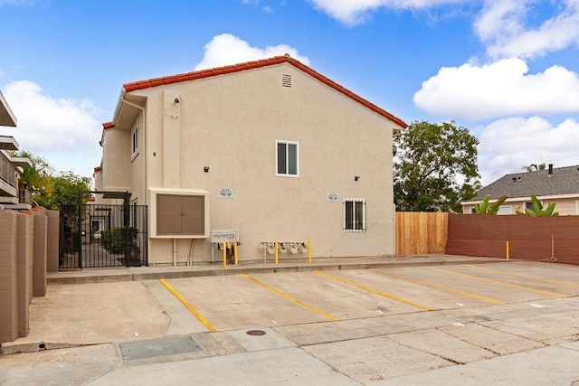 4514 Dawson Ave Unit 4, San Diego, CA 92115 - rear view of house with uncovered parking, stucco siding, and a gate