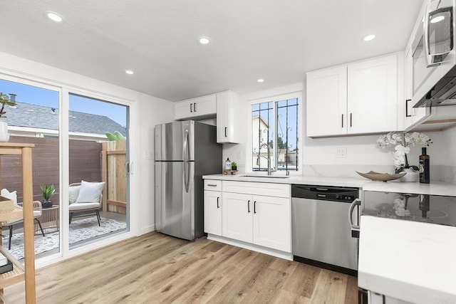 4514 Dawson Ave Unit 4, San Diego, CA 92115 - kitchen featuring appliances with stainless steel finishes, light wood-style flooring, white cabinets, recessed lighting, and light stone countertops