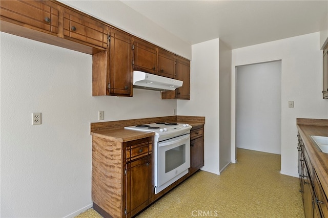 2151 W Pico Ave, Fresno, CA 93705 - kitchen featuring white stove, under cabinet range hood, light flooring, and dark countertops