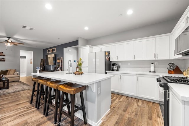 3558 Mt San Gorgonia Ave, Rosamond, CA 93560 - kitchen with gas range oven, freestanding refrigerator, a ceiling fan, light wood finished floors, and open floor plan