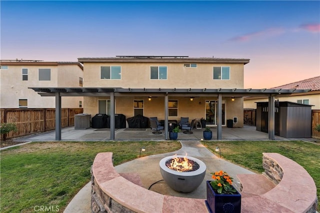 3558 Mt San Gorgonia Ave, Rosamond, CA 93560 - back of house featuring a fire pit, a fenced backyard, roof mounted solar panels, stucco siding, and a patio