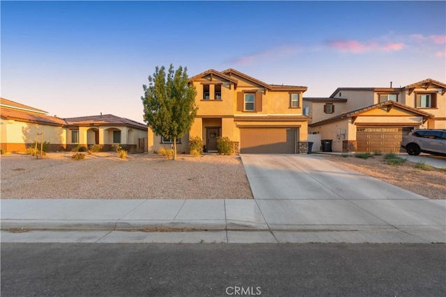 3558 Mt San Gorgonia Ave, Rosamond, CA 93560 - view of front of home featuring driveway, stucco siding, stone siding, and an attached garage
