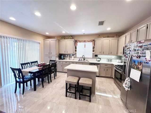 28303 Sycamore Dr, Saugus, CA 91350 - kitchen featuring appliances with stainless steel finishes, a kitchen island, light countertops, tasteful backsplash, and recessed lighting