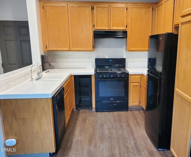 1123 Paseo Las Nubes, Oxnard, CA 93030 - kitchen with black appliances, extractor fan, light wood finished floors, a peninsula, and tile countertops