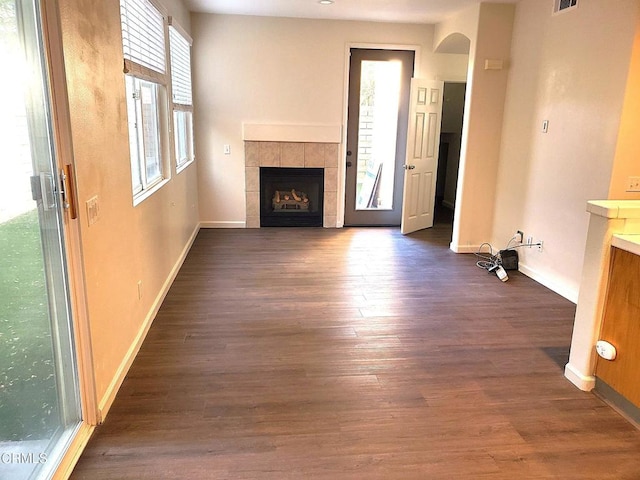 1123 Paseo Las Nubes, Oxnard, CA 93030 - unfurnished living room featuring a tiled fireplace, dark wood finished floors, and arched walkways