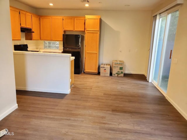 1123 Paseo Las Nubes, Oxnard, CA 93030 - kitchen featuring freestanding refrigerator, tile counters, under cabinet range hood, light wood finished floors, and range