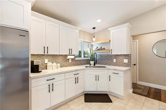 1292 N California Ave, Beaumont, CA 92223 - kitchen with stainless steel refrigerator, white cabinets, tasteful backsplash, light stone countertops, and open shelves