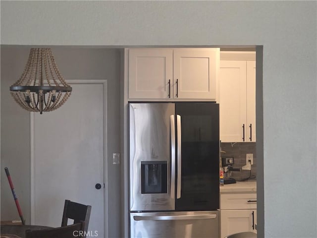 1292 N California Ave, Beaumont, CA 92223 - kitchen with stainless steel refrigerator with ice dispenser, white cabinets, light countertops, decorative backsplash, and a chandelier