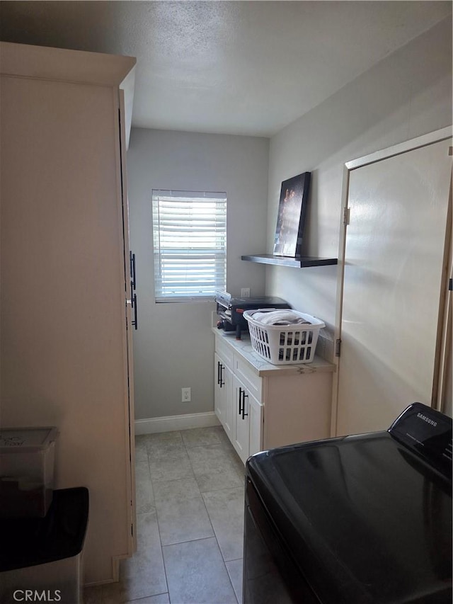 1292 N California Ave, Beaumont, CA 92223 - kitchen featuring washer / clothes dryer, white cabinetry, light countertops, and light tile patterned flooring