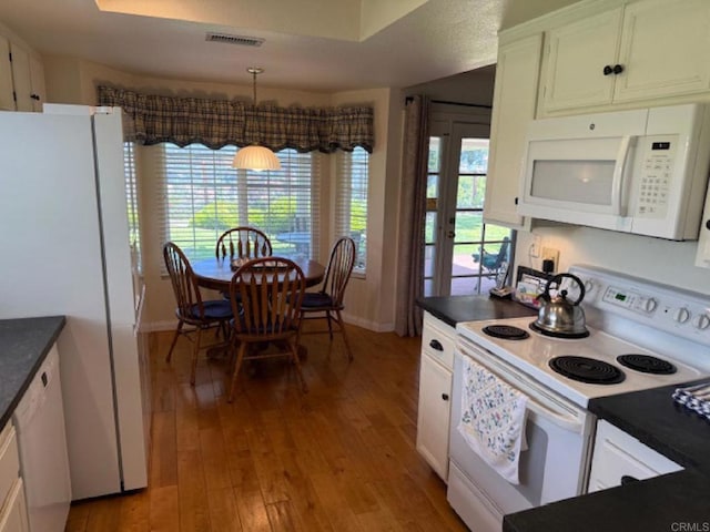 1633 Willowspring Dr N, Encinitas, CA 92024 - kitchen with white appliances, dark countertops, light wood-style floors, white cabinets, and pendant lighting