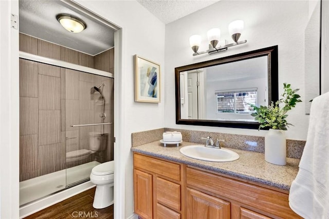 17574 Vandenberg Ln Unit 1, Tustin, CA 92780 - bathroom with a stall shower, vanity, wood finished floors, and a textured ceiling