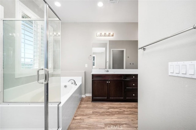 28419 Sunflower St, Highland, CA 92346 - full bath with vanity, a bath, wood finished floors, a stall shower, and recessed lighting
