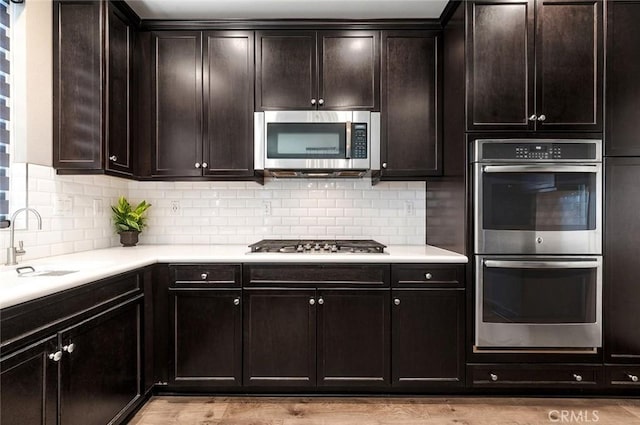 28419 Sunflower St, Highland, CA 92346 - kitchen with stainless steel appliances, light countertops, decorative backsplash, and dark brown cabinetry