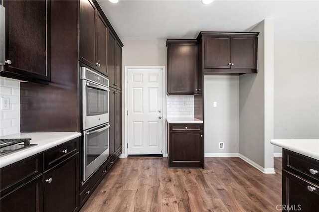 28419 Sunflower St, Highland, CA 92346 - kitchen featuring appliances with stainless steel finishes, tasteful backsplash, light countertops, and dark wood-style flooring