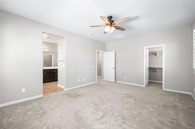 28419 Sunflower St, Highland, CA 92346 - unfurnished bedroom with light carpet, a spacious closet, connected bathroom, and ceiling fan
