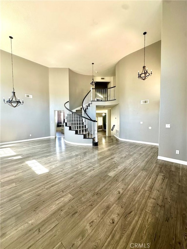 3415 Genoa Pl, Palmdale, CA 93551 - unfurnished living room featuring wood finished floors, stairs, and a chandelier