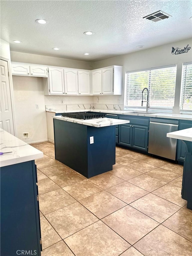 3415 Genoa Pl, Palmdale, CA 93551 - kitchen with stainless steel dishwasher, a textured ceiling, black cooktop, blue cabinets, and white cabinetry