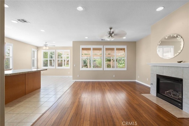 26135 Palm Breeze Ln, Menifee, CA 92586 - unfurnished living room with a ceiling fan, a fireplace, light wood finished floors, healthy amount of natural light, and recessed lighting