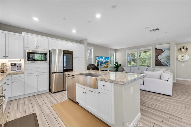 40 Riverton St, Phillips Ranch, CA 91766 - kitchen featuring stainless steel appliances, wood tiled floors, white cabinetry, and recessed lighting