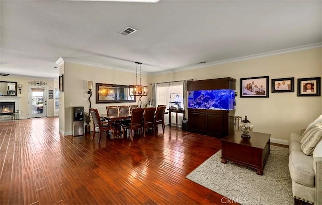 4011 Prestwick Ln, Palmdale, CA 93551 - dining space with wood finished floors, crown molding, and a glass covered fireplace