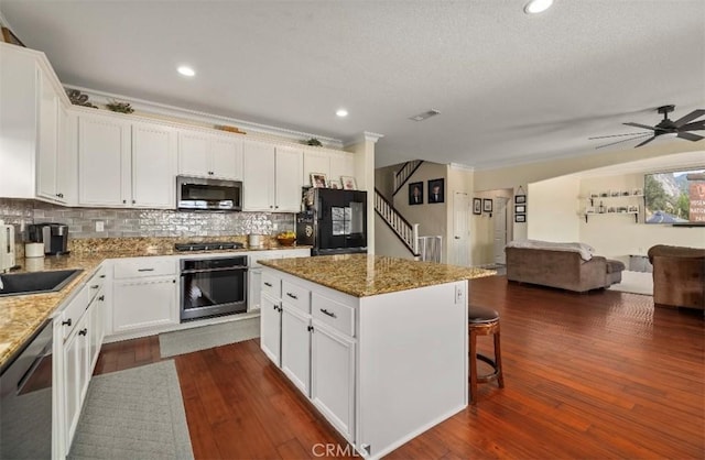 4011 Prestwick Ln, Palmdale, CA 93551 - kitchen featuring appliances with stainless steel finishes, open floor plan, a kitchen breakfast bar, white cabinetry, and recessed lighting