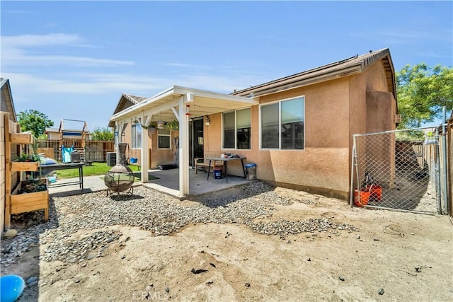 3026 Neary Ct, Rosamond, CA 93560 - rear view of house featuring a patio area, stucco siding, a gate, and a playground