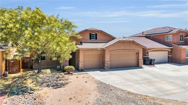 3026 Neary Ct, Rosamond, CA 93560 - view of front of house featuring driveway, stucco siding, stone siding, a garage, and a tiled roof