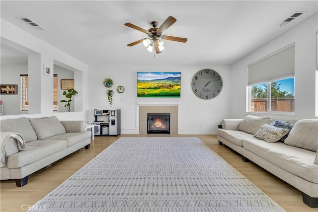 3026 Neary Ct, Rosamond, CA 93560 - living area featuring light wood-style floors, a ceiling fan, and a tile fireplace